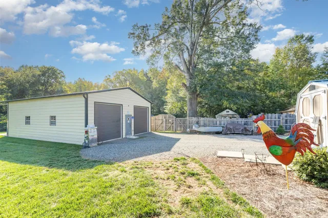 a view of a backyard with a garden and tree