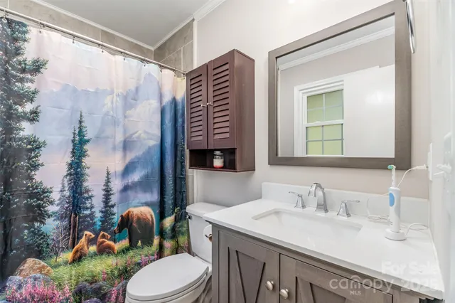 a bathroom with a granite countertop toilet sink and mirror