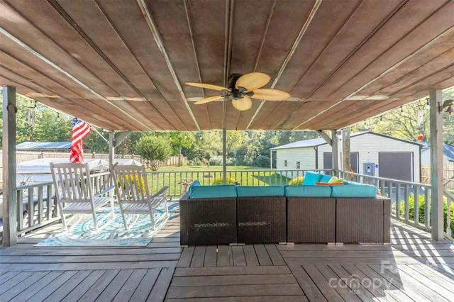 a view of a deck with a table and chairs under an umbrella with a small yard
