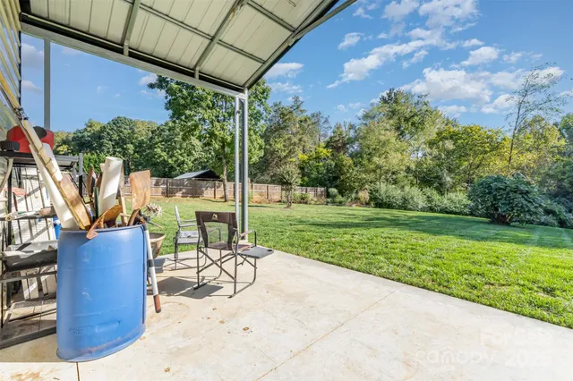 a view of a patio with a table chairs and a yard