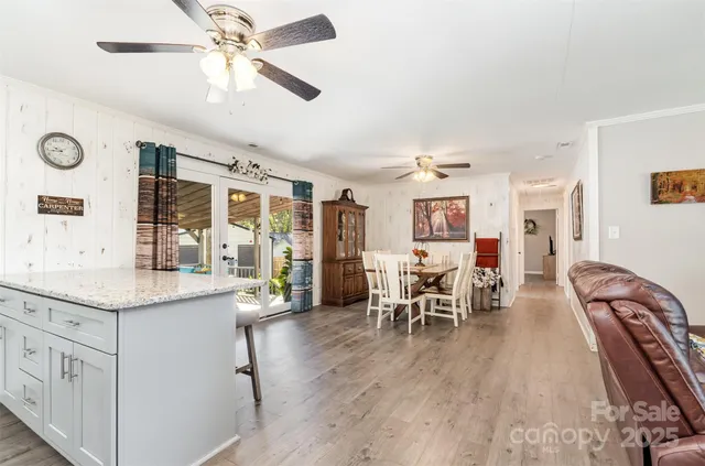 a very nice looking dining room with kitchen island furniture a chandelier and a large window