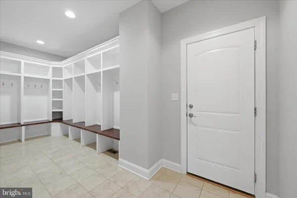 a view of staircase with lots of frames on wall and wooden floor