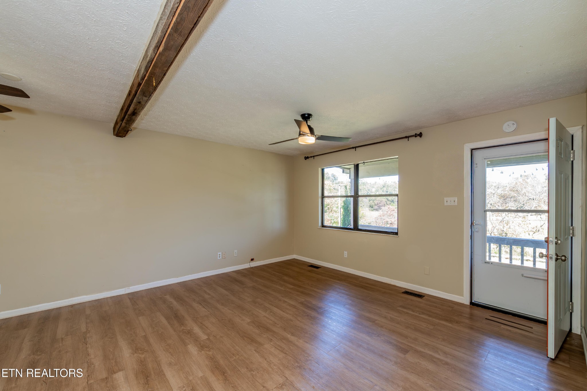 759 Laurel Road Clinton, TN 37716 - Photo 11 of 28 an empty room with wooden floor and windows