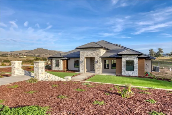 a front view of a house with a garden and yard
