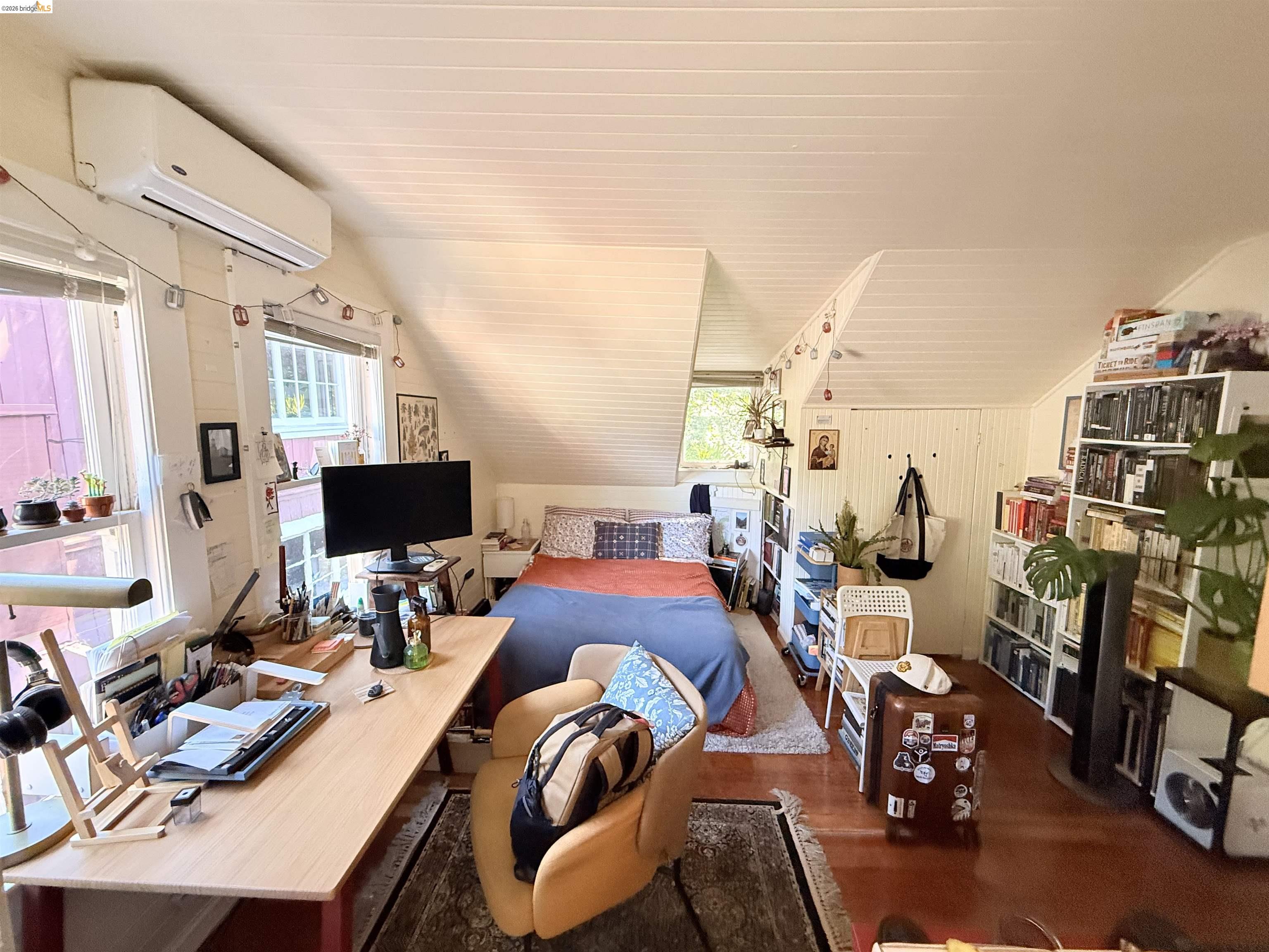1631 La Vereda Road Berkeley, CA 94709 - Photo 29 of 42 Attic space featuring wood-finish flooring, white paneled walls, and a sloped white paneled ceiling