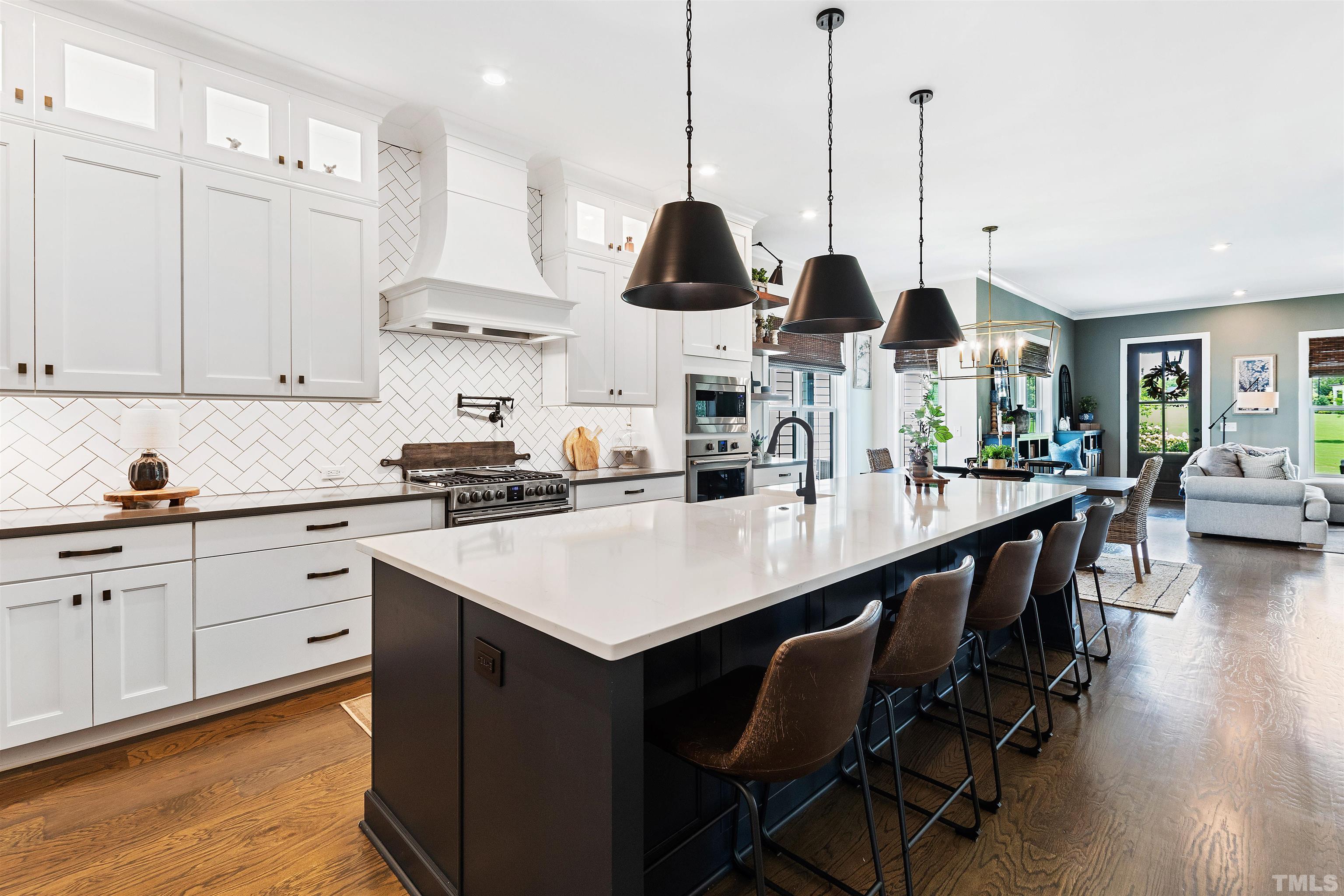 700 Daniel Ridge Rd. Wendell, NC 27591 - Photo 16 of 62 a kitchen with stainless steel appliances kitchen island granite countertop a table chairs and white cabinets