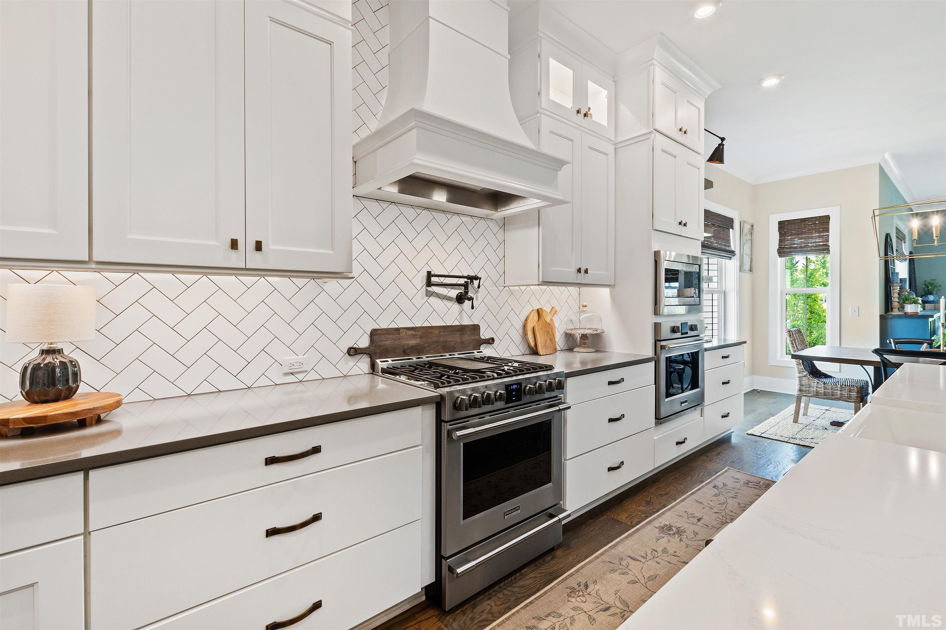 700 Daniel Ridge Rd. Wendell, NC 27591 - Photo 20 of 62 a kitchen with stainless steel appliances white cabinets and a stove top oven
