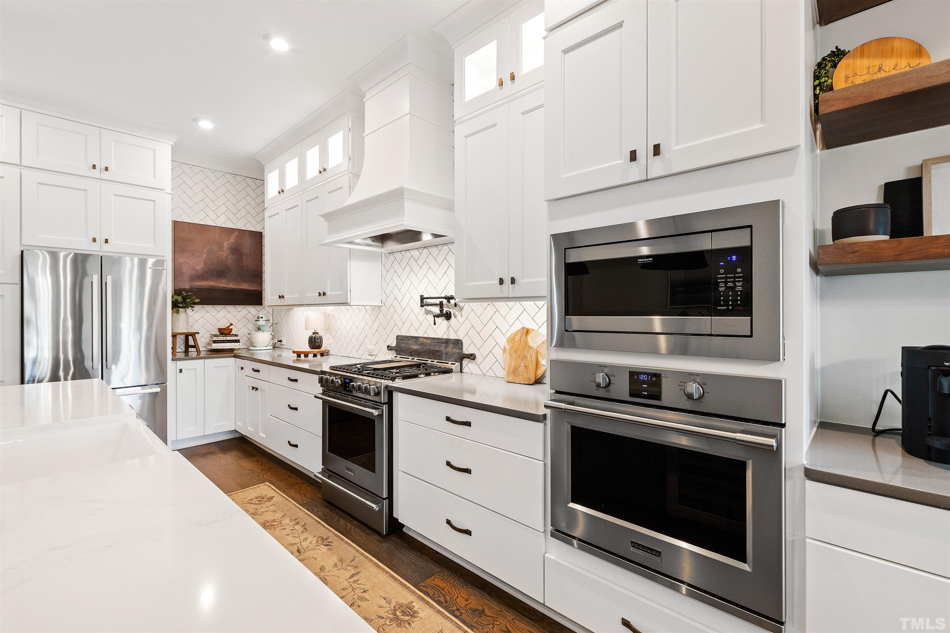 700 Daniel Ridge Rd. Wendell, NC 27591 - Photo 21 of 62 a kitchen with stainless steel appliances white cabinets and a stove a oven with wooden floor