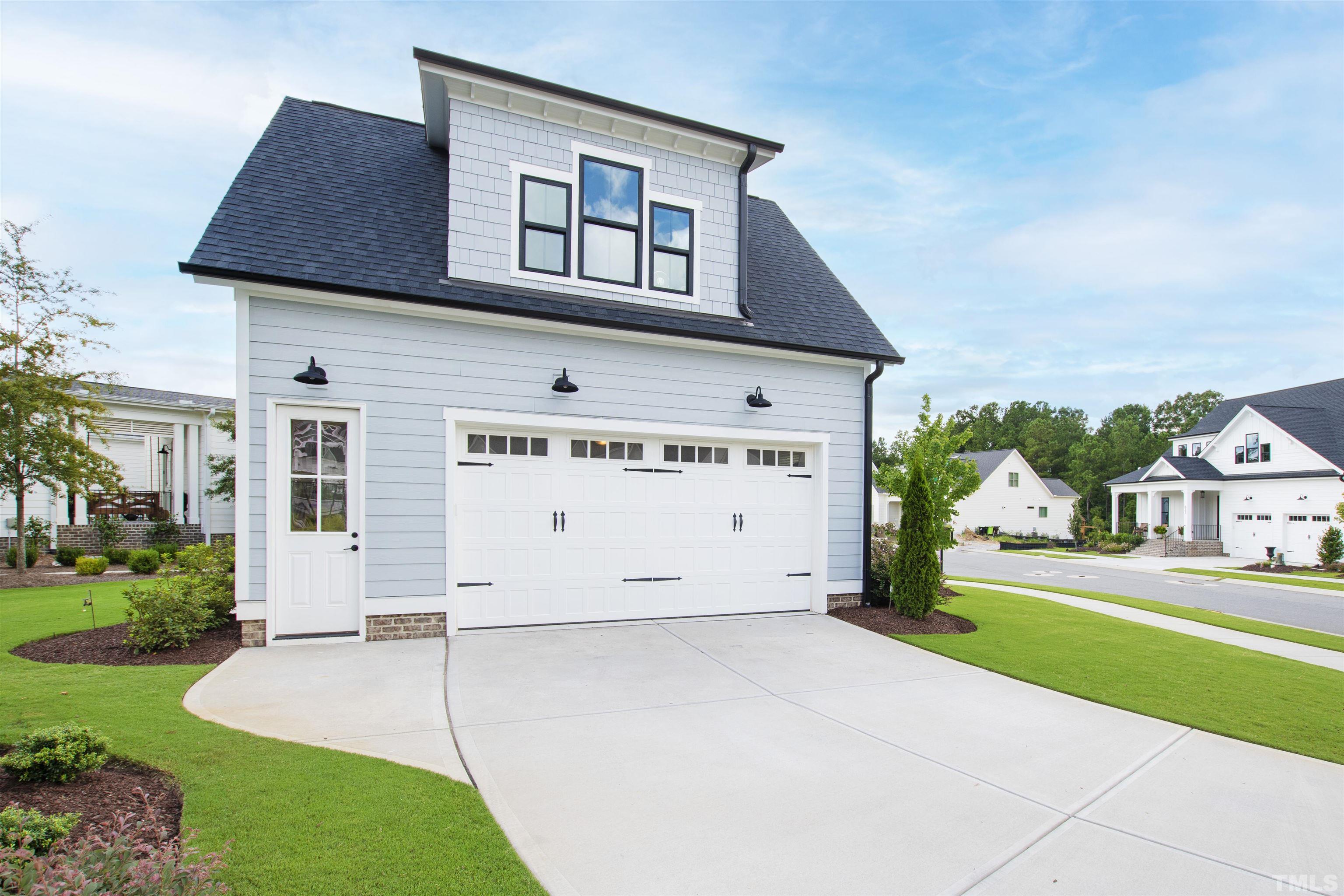 700 Daniel Ridge Rd. Wendell, NC 27591 - Photo 60 of 62 a front view of a house with a garden and garage