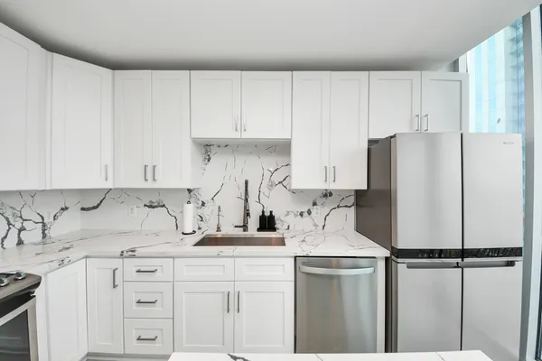 a kitchen with appliances a sink and cabinets