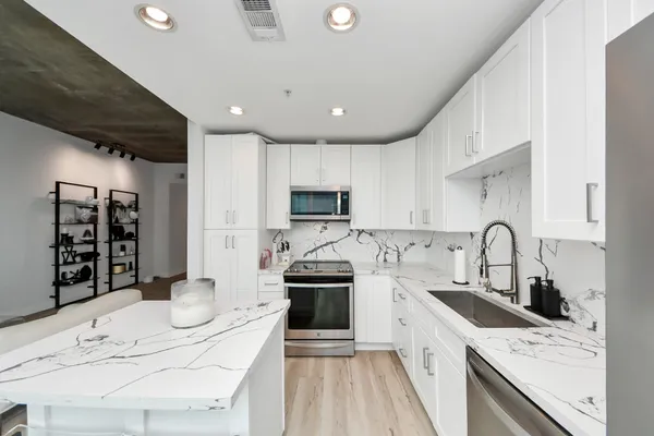 a kitchen with granite countertop a stove sink and cabinets