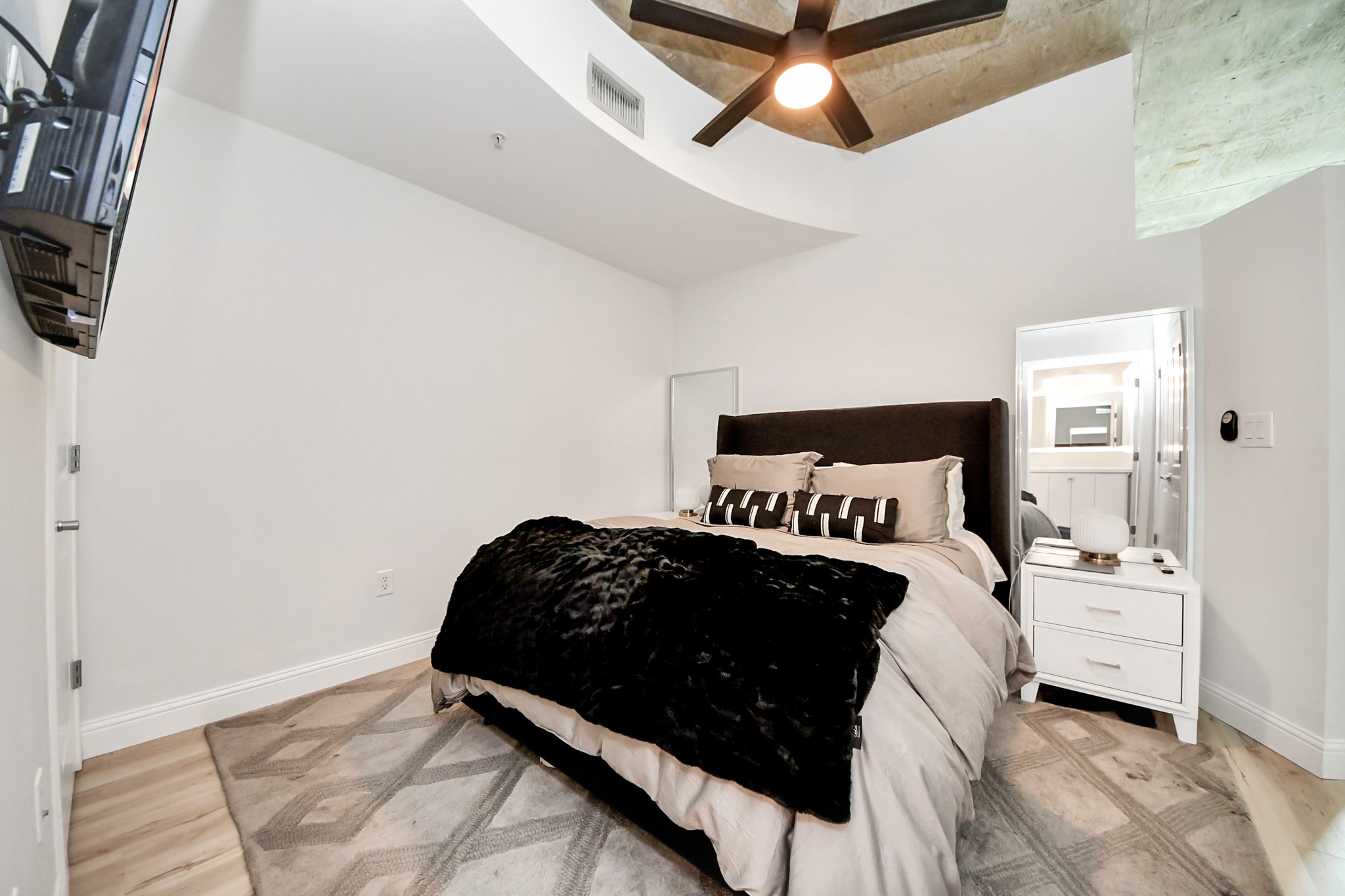 5925 Almeda Road, Unit 11616 Houston, TX 77004 - Photo 18 of 39 a bedroom with a bed and a tv on the dresser