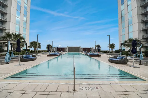 a view of a patio with couches table and chairs with potted plants and big yard