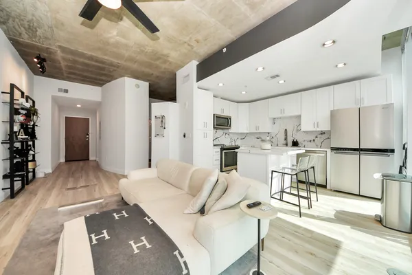 a living room with stainless steel appliances kitchen island granite countertop furniture and a kitchen view