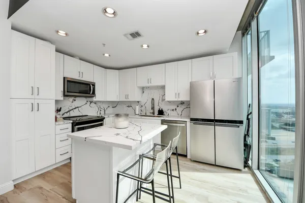 a kitchen with stainless steel appliances a refrigerator stove microwave and cabinets