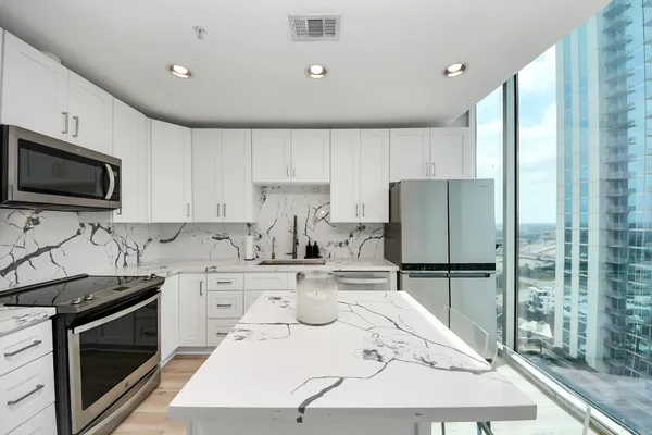 a kitchen with stainless steel appliances a stove a sink a refrigerator and cabinets