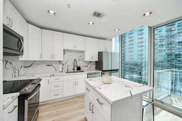 a kitchen with a sink a stove a refrigerator and cabinets