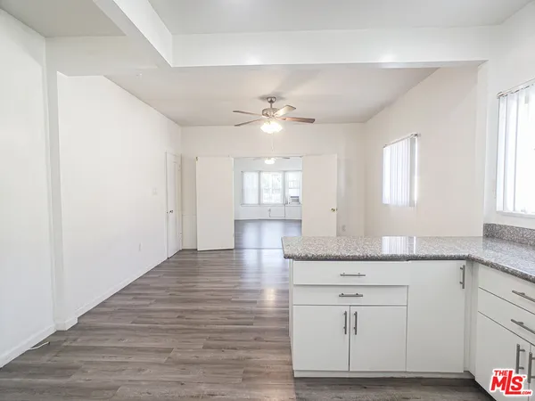 a kitchen with granite countertop white cabinets and white appliances