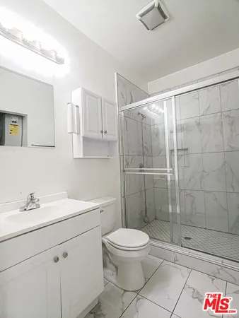 a bathroom with a toilet sink a shower and vanity