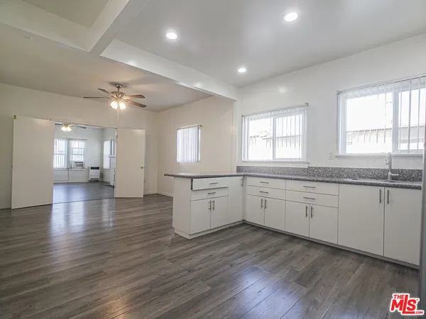 a large kitchen with a lot of counter space and wooden floor