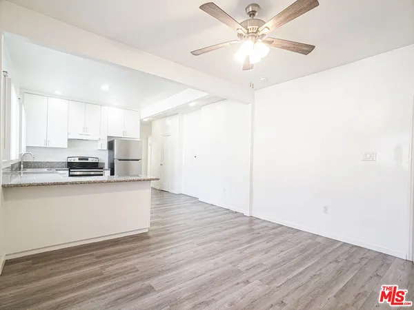a view of kitchen with granite countertop cabinets and refrigerator