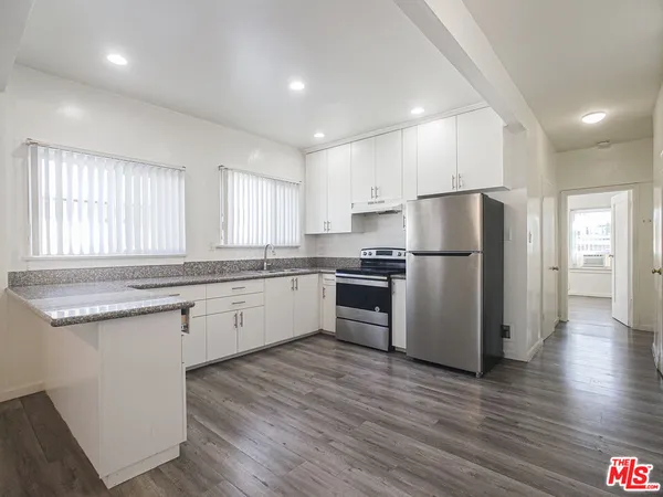 a kitchen with a refrigerator a sink and wooden cabinets