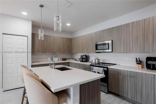 a kitchen that has a sink a stove and chairs