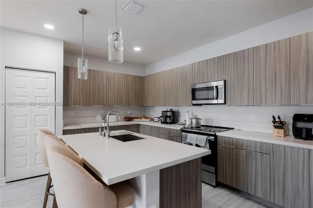 a kitchen that has a sink a stove and chairs