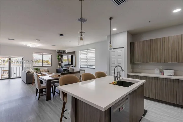 a kitchen with stainless steel appliances granite countertop a sink a stove and a refrigerator