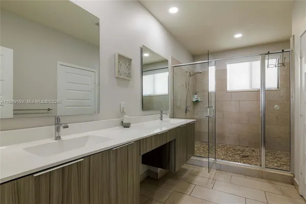 a bathroom with a shower sink and mirror