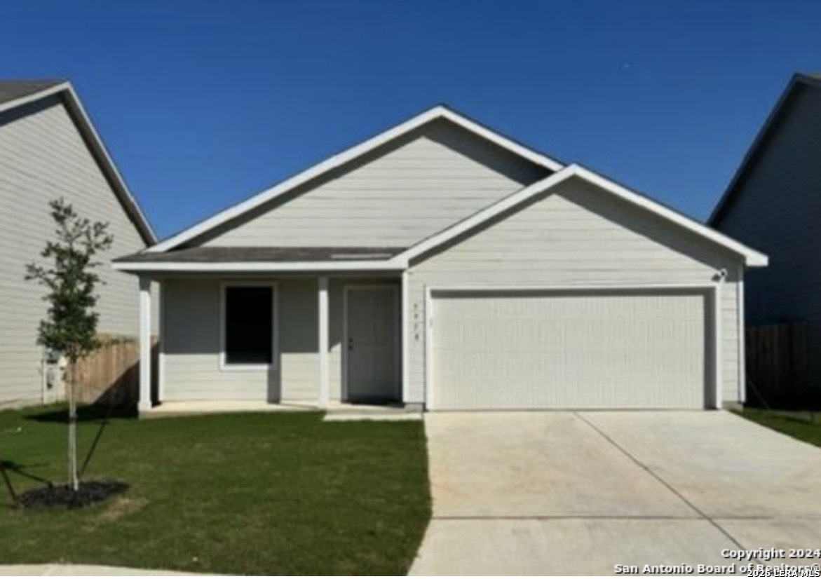 a view of a house with a yard and garage