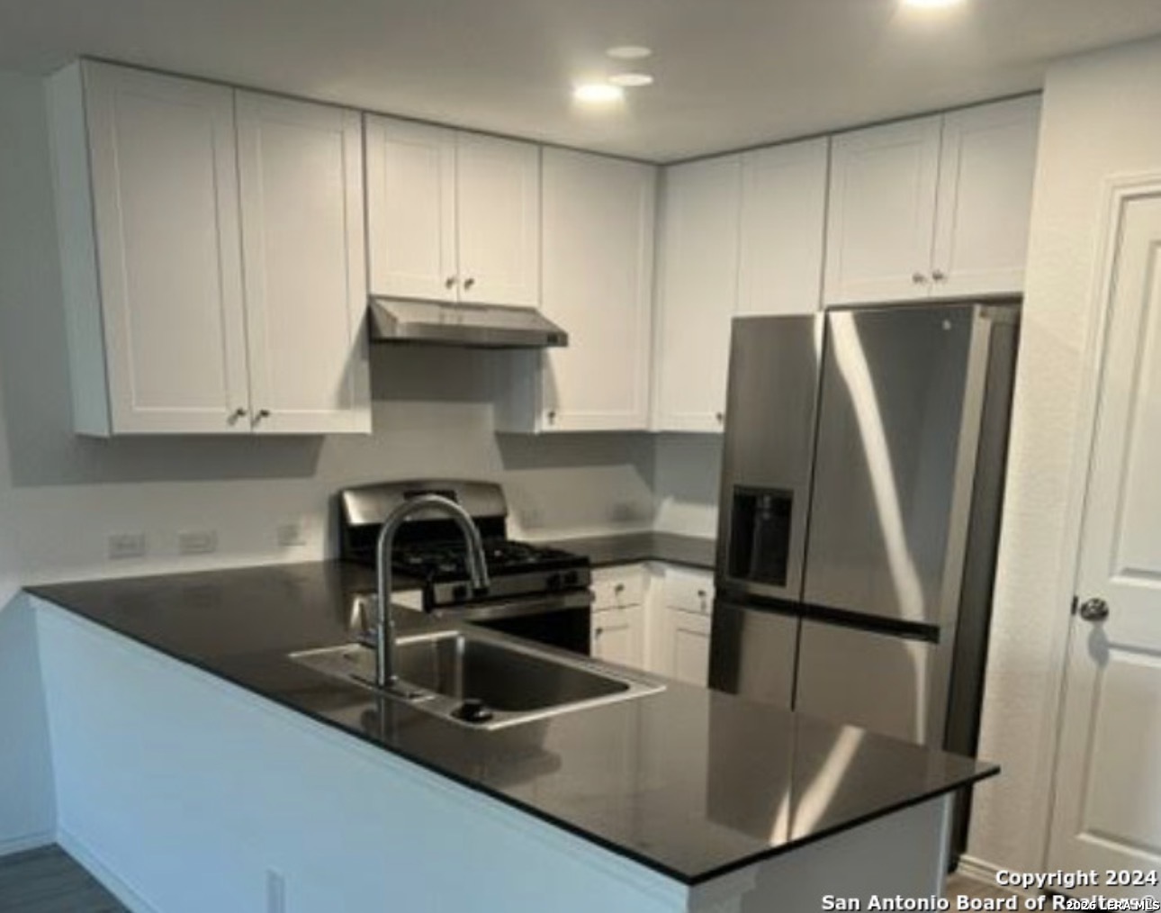 5958 Companion Loop Bulverde, TX 78163 - Photo 2 of 12 a kitchen with stainless steel appliances granite countertop a sink a refrigerator and a granite counter tops