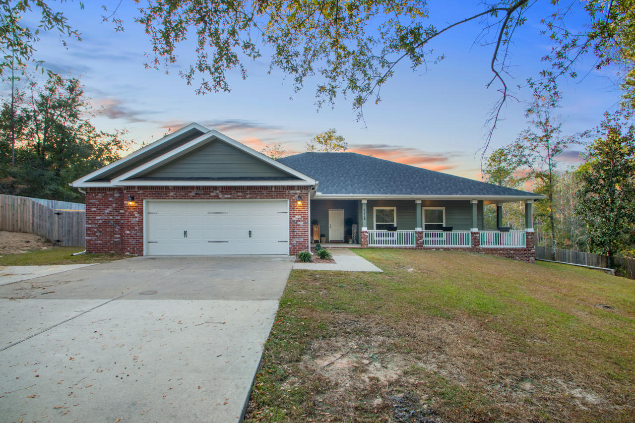 6318 Possum Ridge Road Crestview, FL 32539 - Photo 1 of 20 a front view of a house with a yard and garage