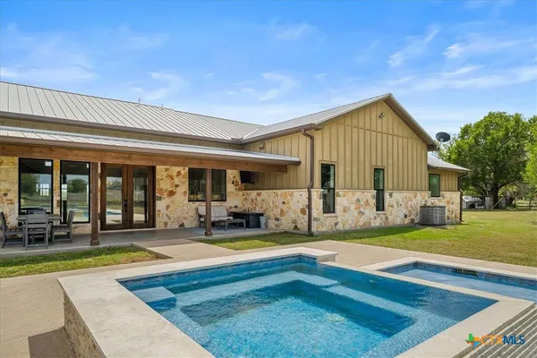 a view of house with yard outdoor seating and covered with trees