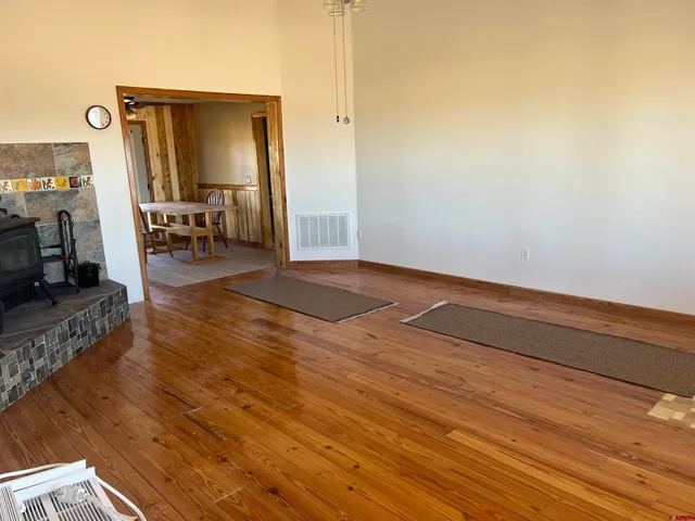 a view of a dining room with furniture a rug and wooden floor