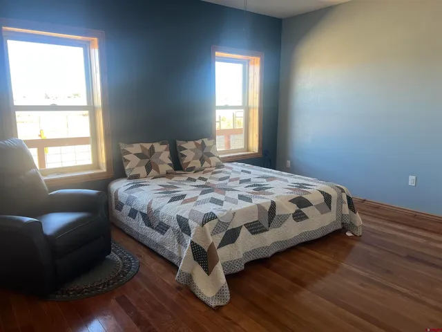 a bedroom with a bed ceiling fan and window