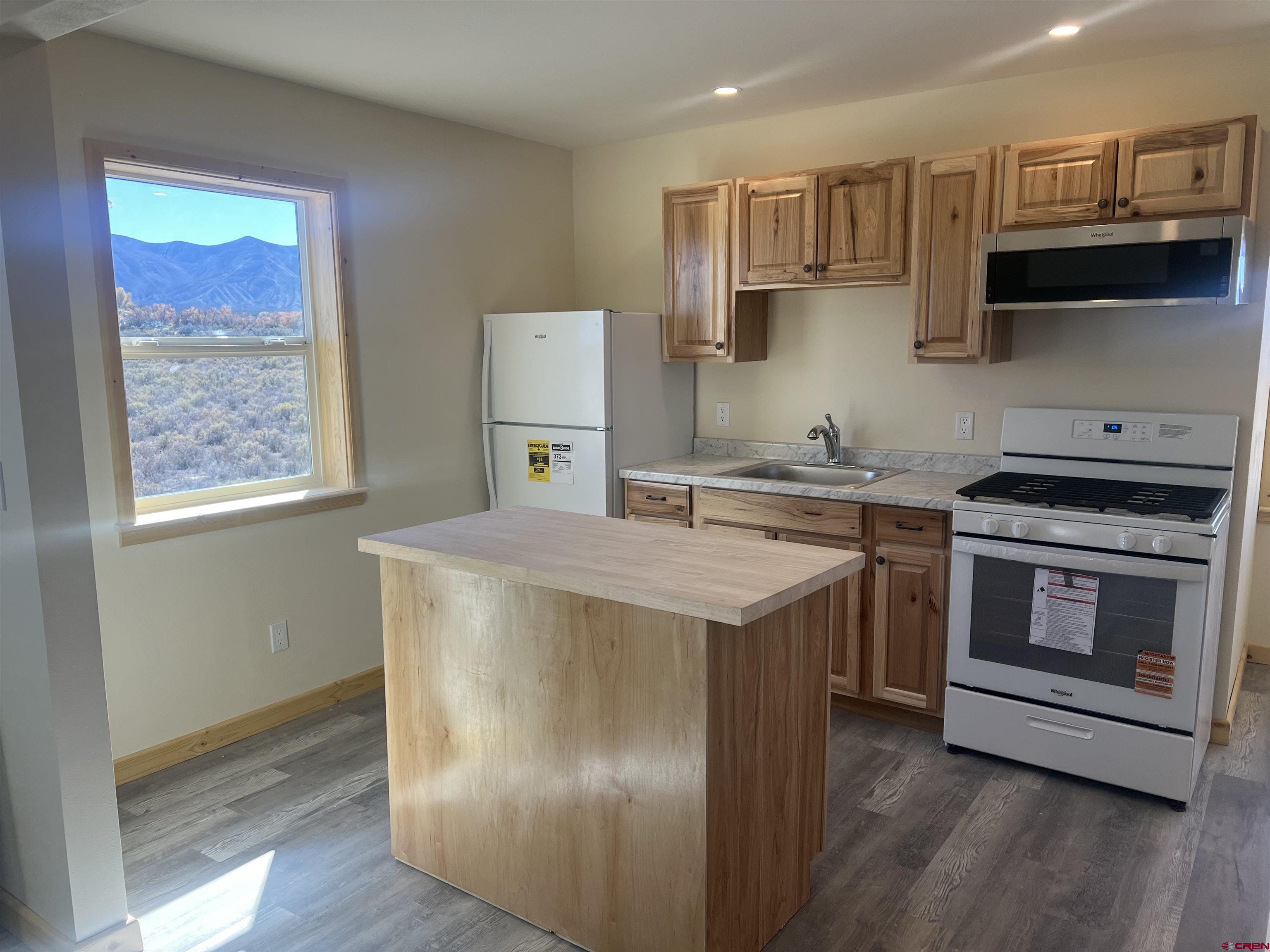 8504 Road 27 Cortez, CO 81321 - Photo 20 of 43 a kitchen with stainless steel appliances granite countertop a stove a sink and a microwave