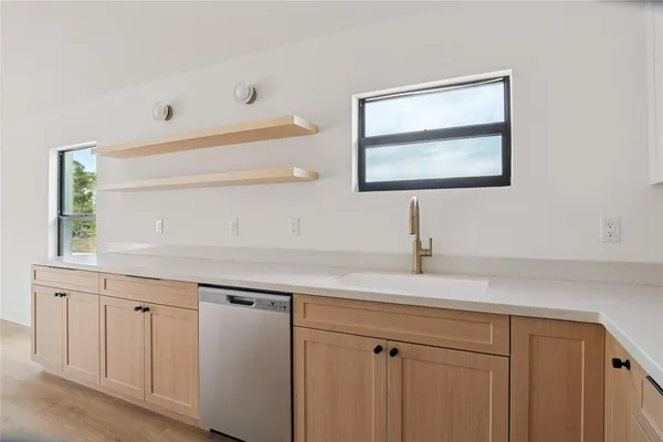 a kitchen with white cabinets and wooden floors