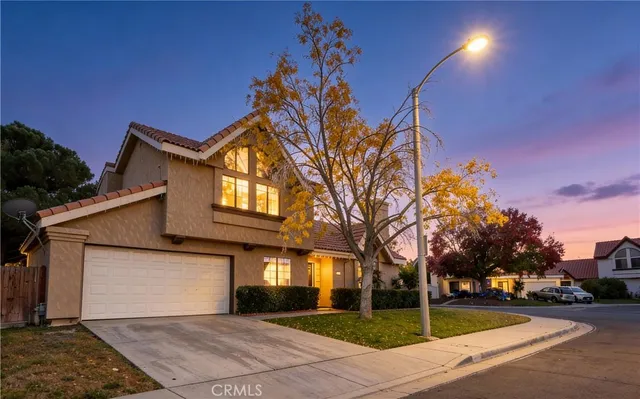 a front view of a house with a yard and potted plants