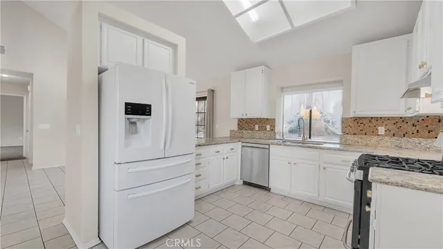 a kitchen with white cabinets and white appliances