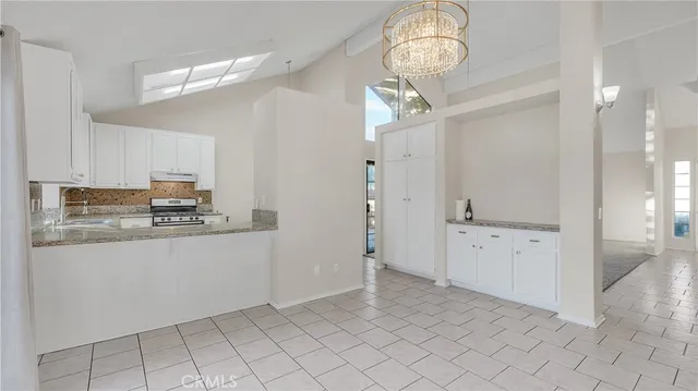 a kitchen with granite countertop a sink a stove and cabinets