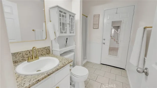 a bathroom with a granite countertop sink toilet and shower
