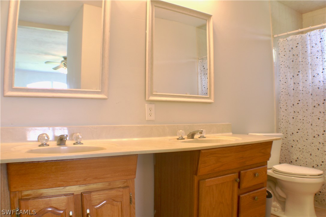 12210 Shawnee Road Fort Myers, FL 33913 - Photo 14 of 28 a bathroom with a sink a toilet and a mirror