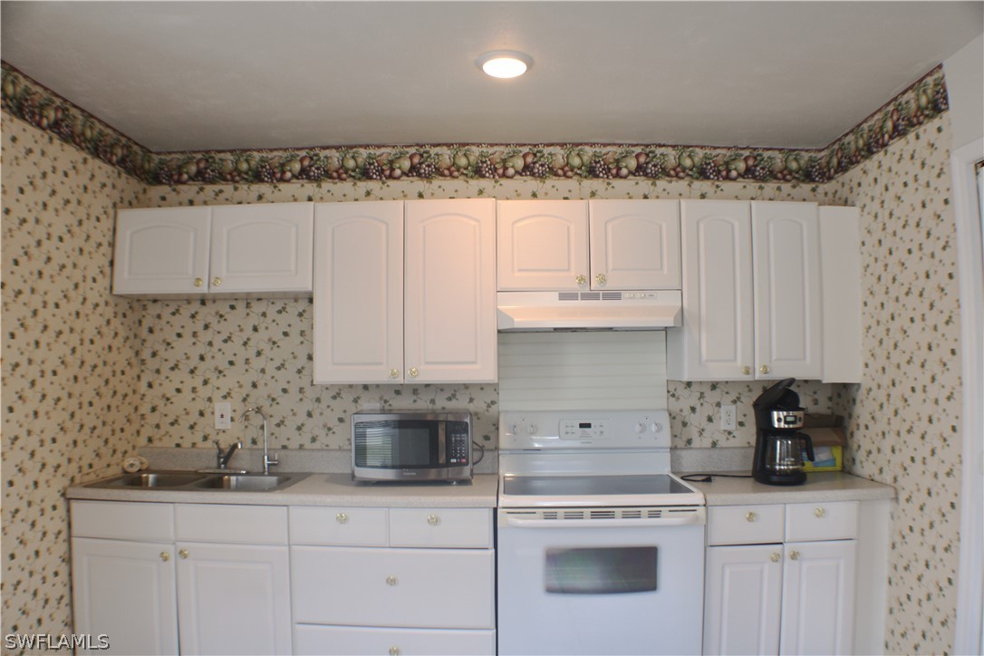 12210 Shawnee Road Fort Myers, FL 33913 - Photo 22 of 28 a kitchen with granite countertop white cabinets and white appliances