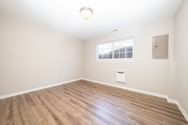 4313 Timber Ridge Court Joliet, IL 60431 - Photo 23 of 25 an empty room with wooden floor and windows