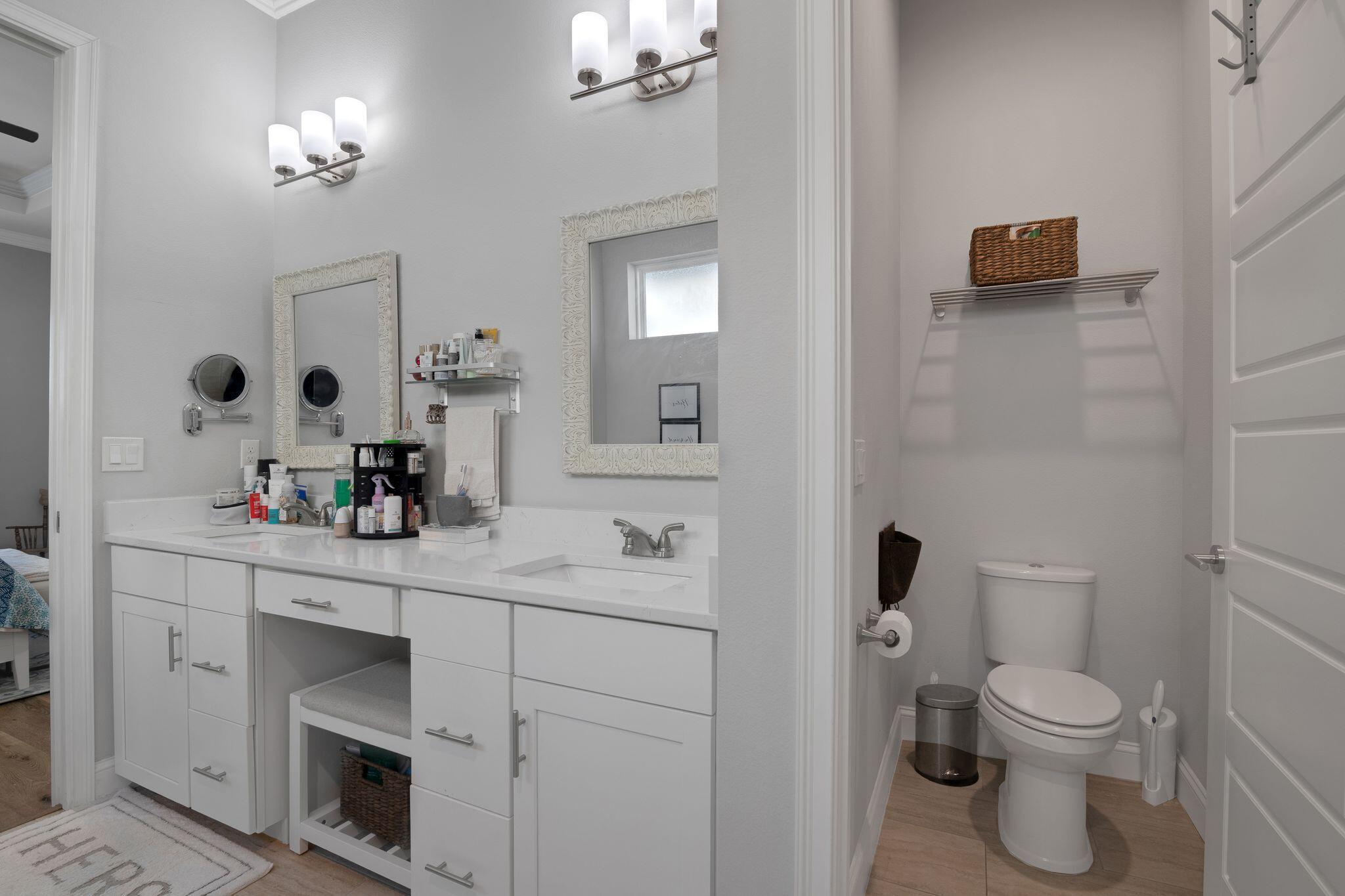 6450 Southwest 77th Street Gainesville, FL 32608 - Photo 24 of 30 a bathroom with a toilet a sink a mirror and vanity