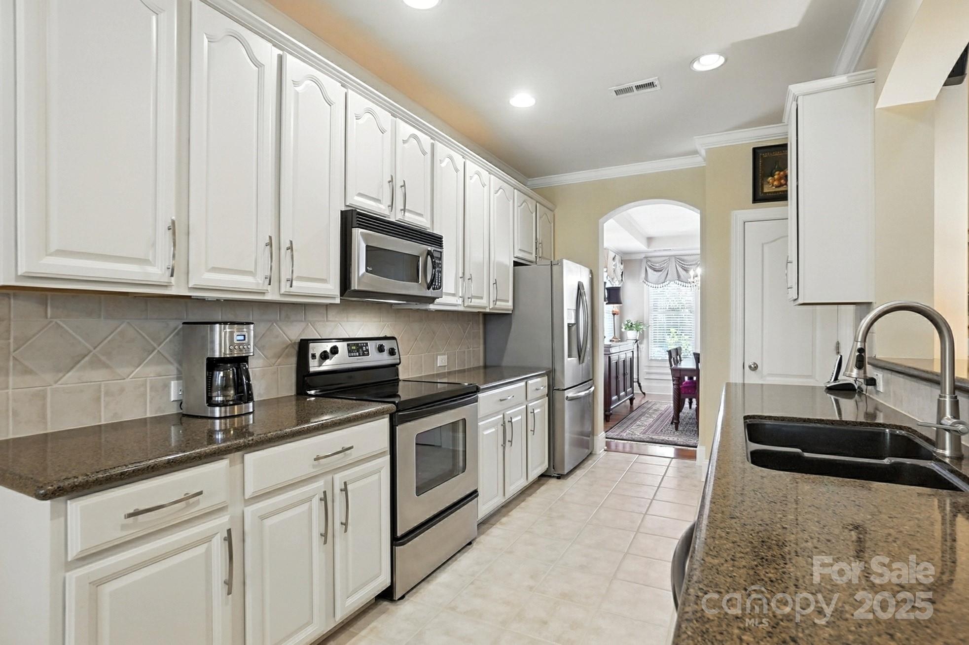 10906 Round Rock Road Charlotte, NC 28277 - Photo 12 of 45 a kitchen with stainless steel appliances granite countertop a stove a sink and a white refrigerator with white cabinets