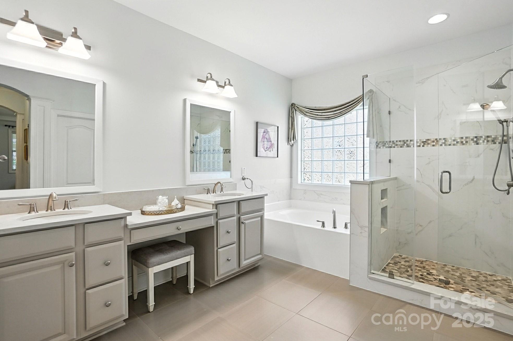10906 Round Rock Road Charlotte, NC 28277 - Photo 19 of 45 a spacious bathroom with a double vanity sink double mirror and bathtub