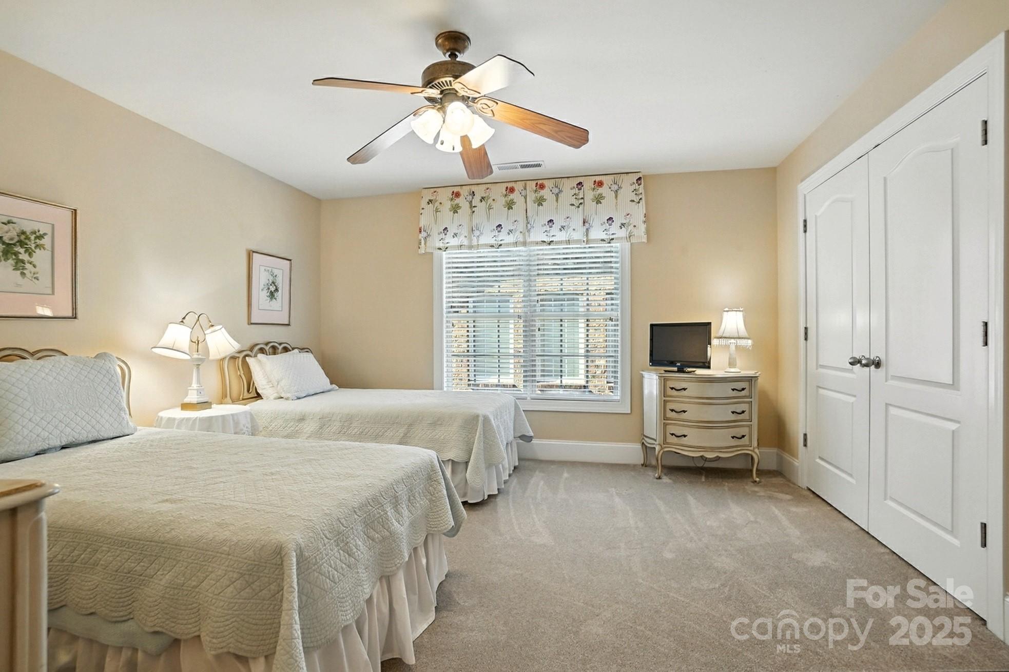 10906 Round Rock Road Charlotte, NC 28277 - Photo 32 of 45 a spacious bedroom with a bed a chandelier and a flat screen tv