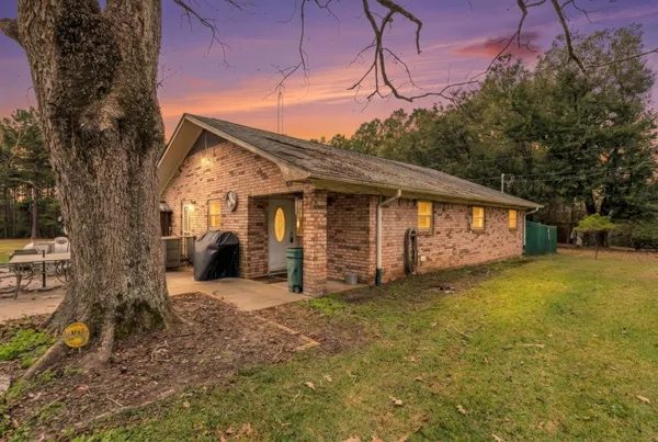 a view of a house with backyard and sitting area